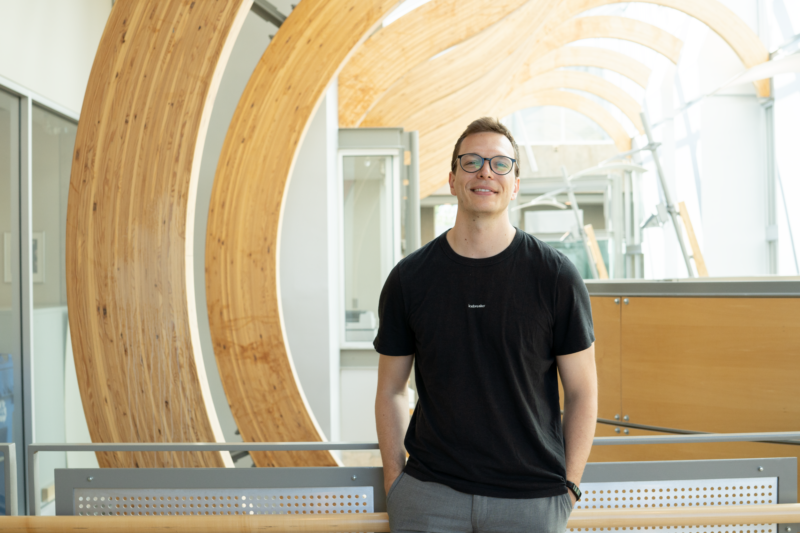 Tokuriki lab member and Gilbert award recipient Karol Buda smiles to camera from inside the Michael Smith Laboratories building.